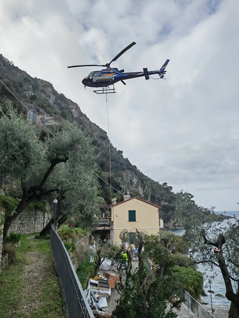 A helicopter carrying a load over the house during the renovation