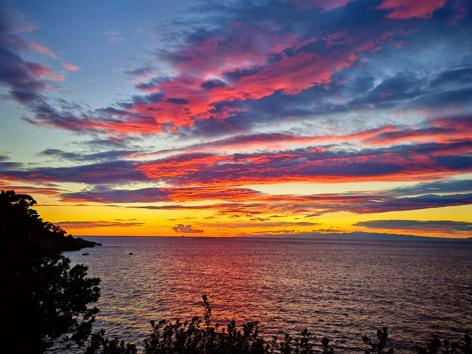A red and gold sunset over the sea at Punta Chiappa